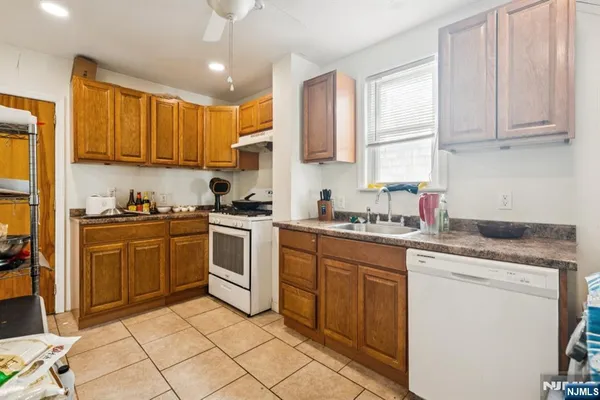 a kitchen with granite countertop cabinets sink and white appliances