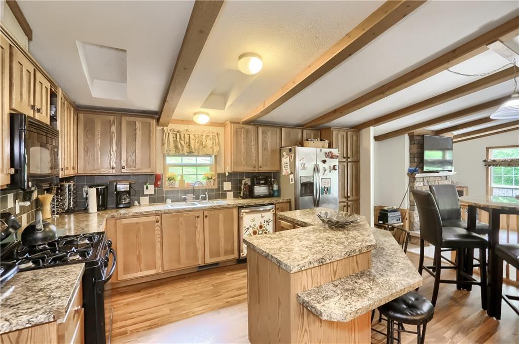 4425 State Rte 18 New Castle, PA 16102 - Photo 6 of 22 a kitchen with granite countertop kitchen island wooden cabinets and stainless steel appliances