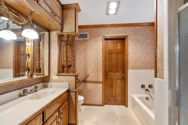 a bathroom with a tub sink and mirror