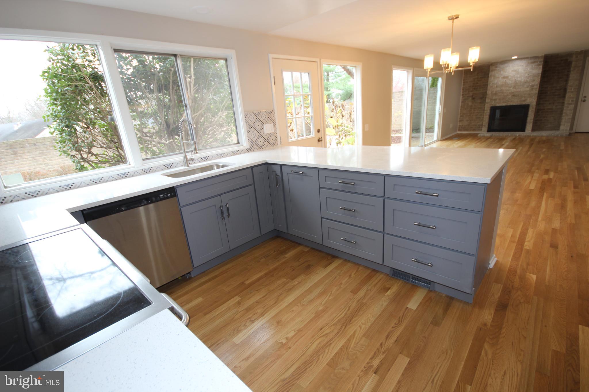 19115 Roman Way Montgomery Village, MD 20886 - Photo 11 of 67 a large kitchen with kitchen island granite countertop wooden floor a large window and a sink