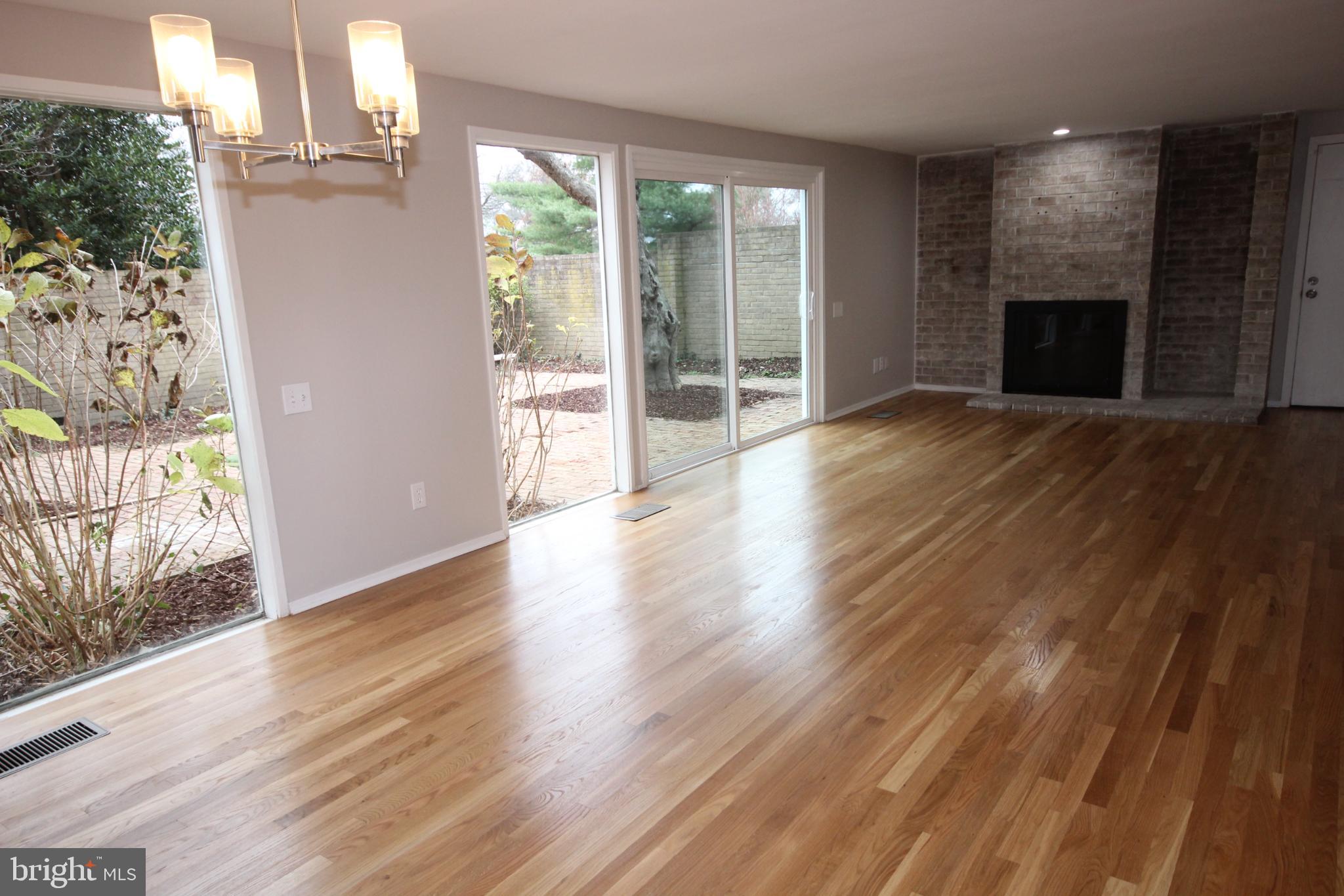 19115 Roman Way Montgomery Village, MD 20886 - Photo 15 of 67 an empty room with wooden floor fireplace and windows