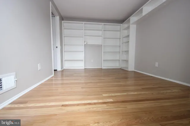 a view of empty room with wooden floor