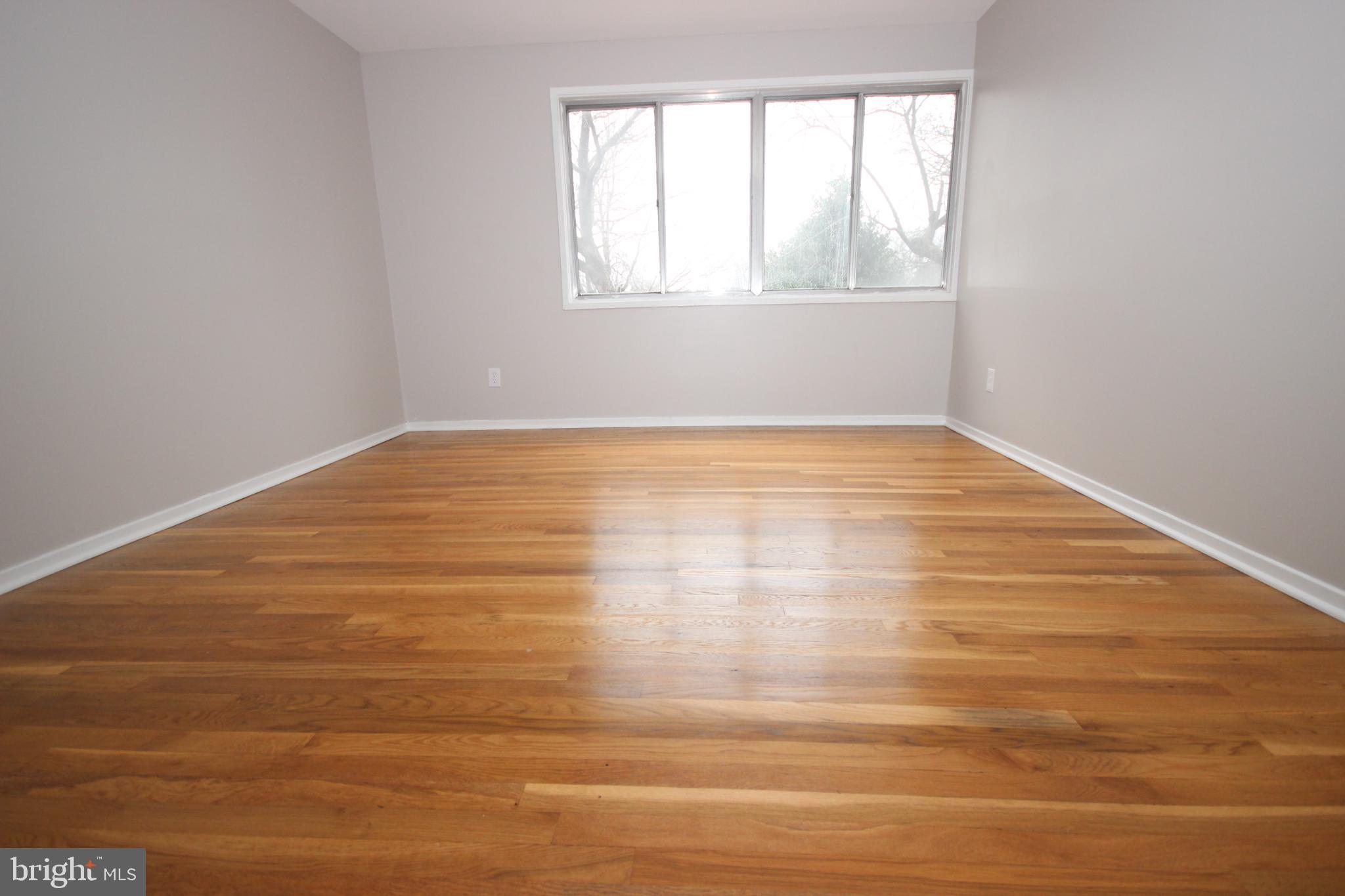 19115 Roman Way Montgomery Village, MD 20886 - Photo 45 of 67 a view of an empty room with wooden floor and a window