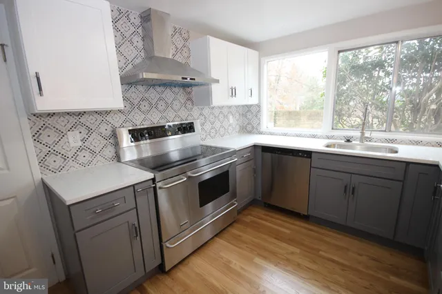 a kitchen with granite countertop a stove top oven and cabinets