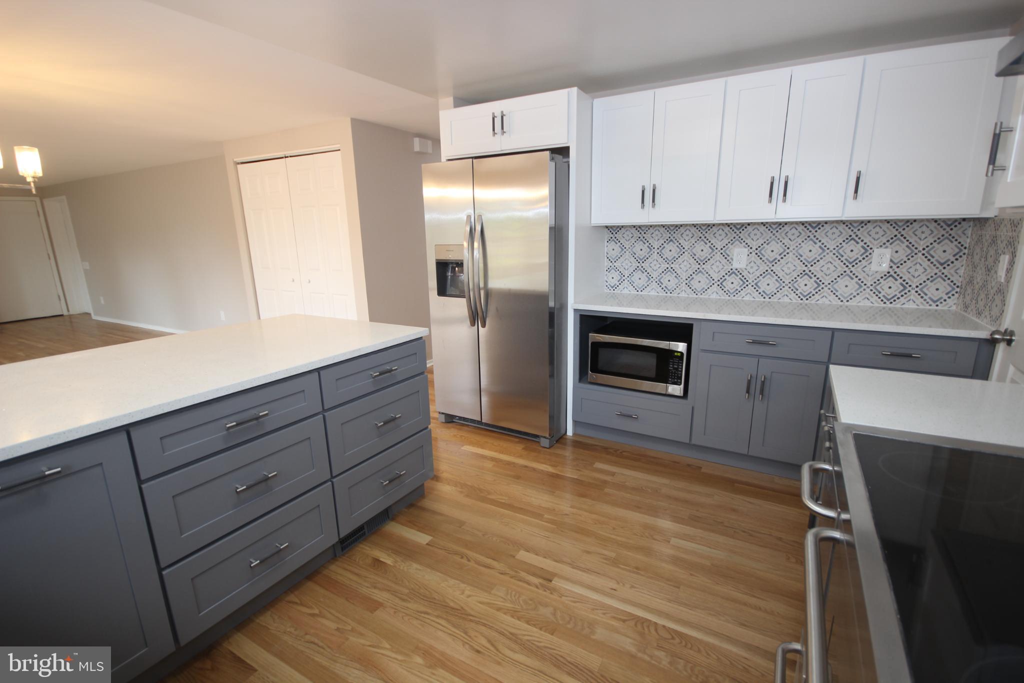 19115 Roman Way Montgomery Village, MD 20886 - Photo 6 of 67 a kitchen with a refrigerator stove and white cabinets