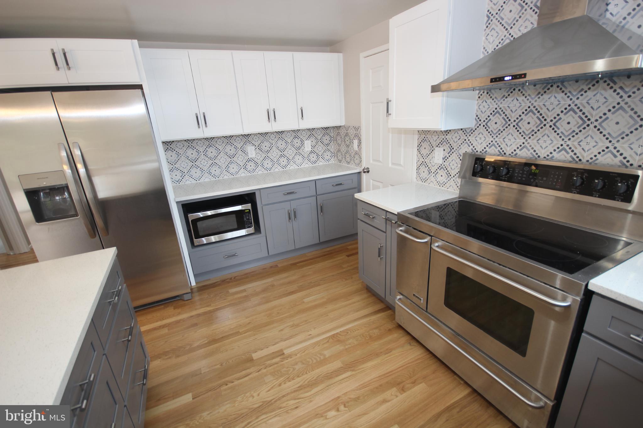 19115 Roman Way Montgomery Village, MD 20886 - Photo 7 of 67 a kitchen with granite countertop a stove top oven and cabinets