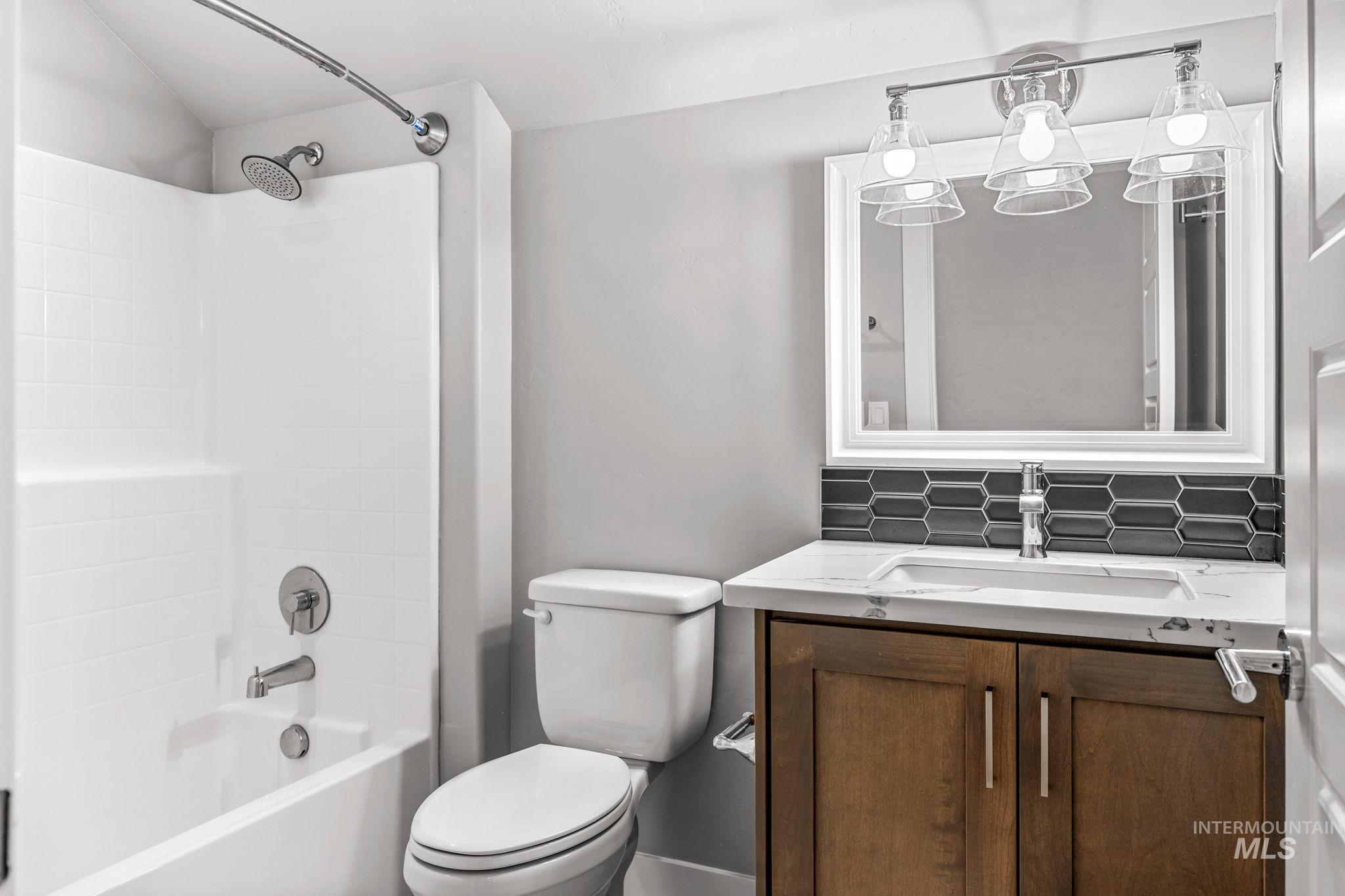 2934 East Murchison Street Meridian, ID 83642 - Photo 36 of 44 Bathroom featuring a single vanity with wood-finish cabinetry, a white countertop, and a rectangular undermount sink