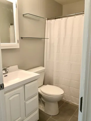 627 South Virginia Road, Unit 312 Crystal Lake, IL 60014 - Photo 10 of 13 a bathroom with a white toilet sitting next to a white sink and a shower curtain