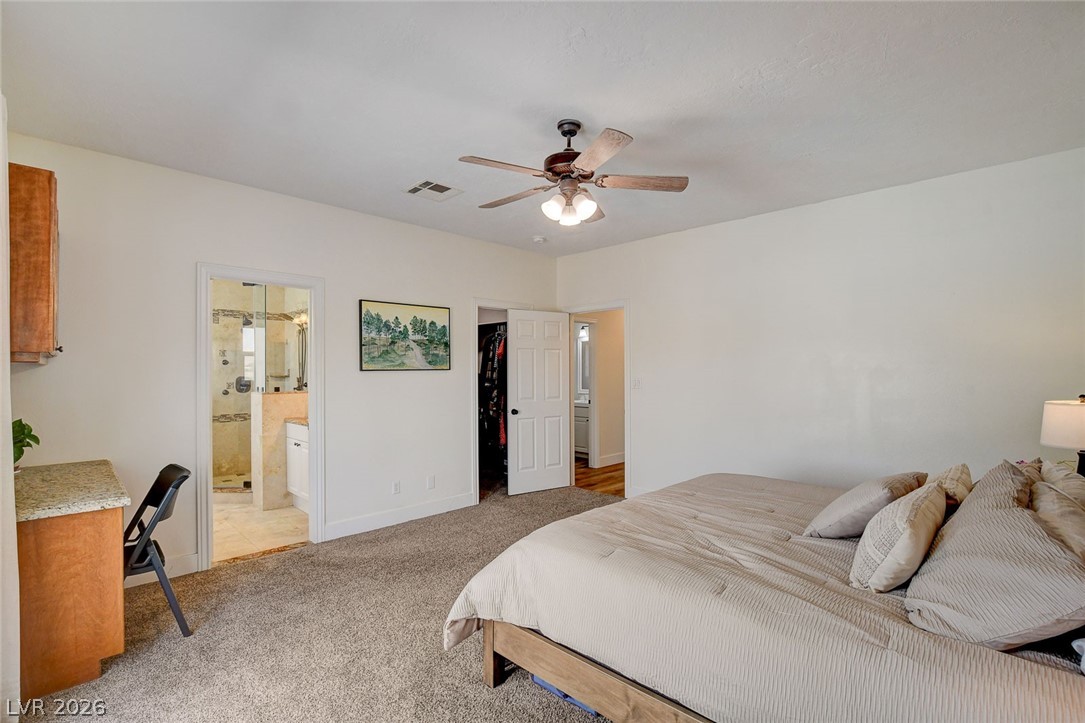 4362 Thistle Street Logandale, NV 89021 - Photo 28 of 99 A well-appointed bedroom suite offers a ceiling fan, plush carpet, and convenient access to an en-suite bathroom and closet.