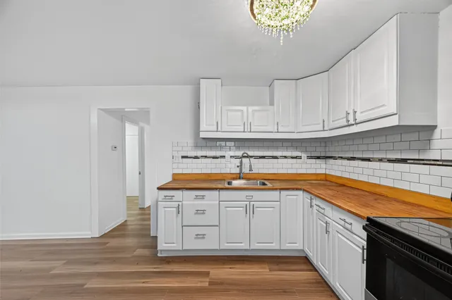 a kitchen with stainless steel appliances granite countertop a sink and dishwasher with white cabinets
