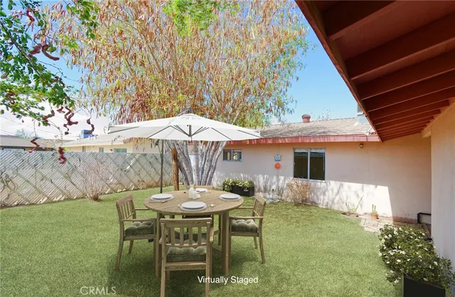 a backyard of a house with table and chairs