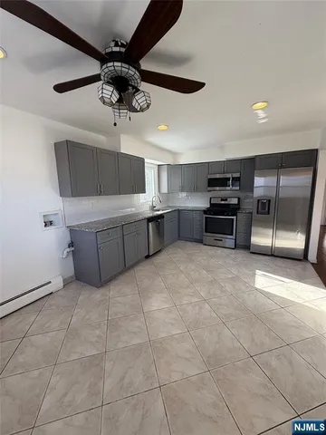 a kitchen with stainless steel appliances a stove a refrigerator and cabinets