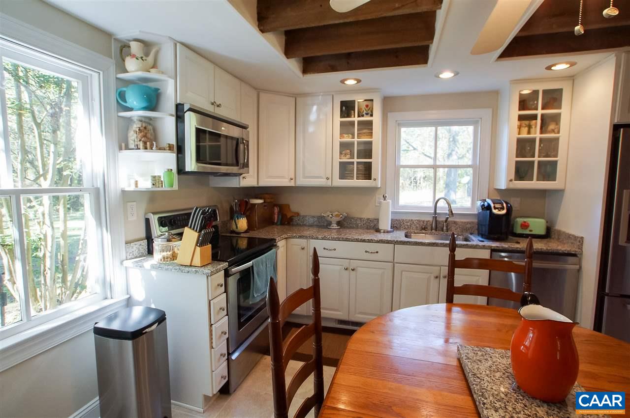 3759 Courthouse Road Louisa, VA 23093 - Photo 10 of 29 a kitchen with stainless steel appliances granite countertop a stove top oven a sink dishwasher a dining table and chairs with wooden floor