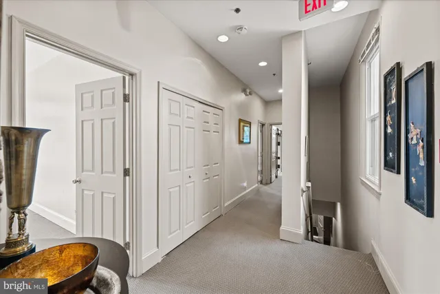 a view of a hallway with workspace and a couch