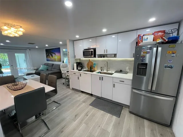 a kitchen with stainless steel appliances kitchen island granite countertop a sink and cabinets