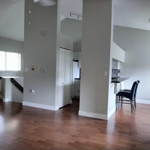 a view of a kitchen with furniture and wooden floor
