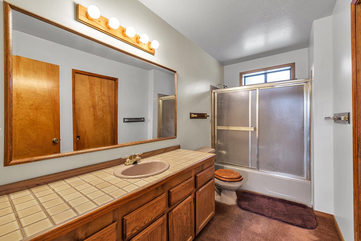 11780 Oslo Drive Truckee, CA 96161 - Photo 17 of 21 a bathroom with a granite countertop sink toilet and shower