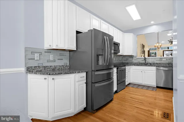 a kitchen with granite countertop a sink stove and refrigerator