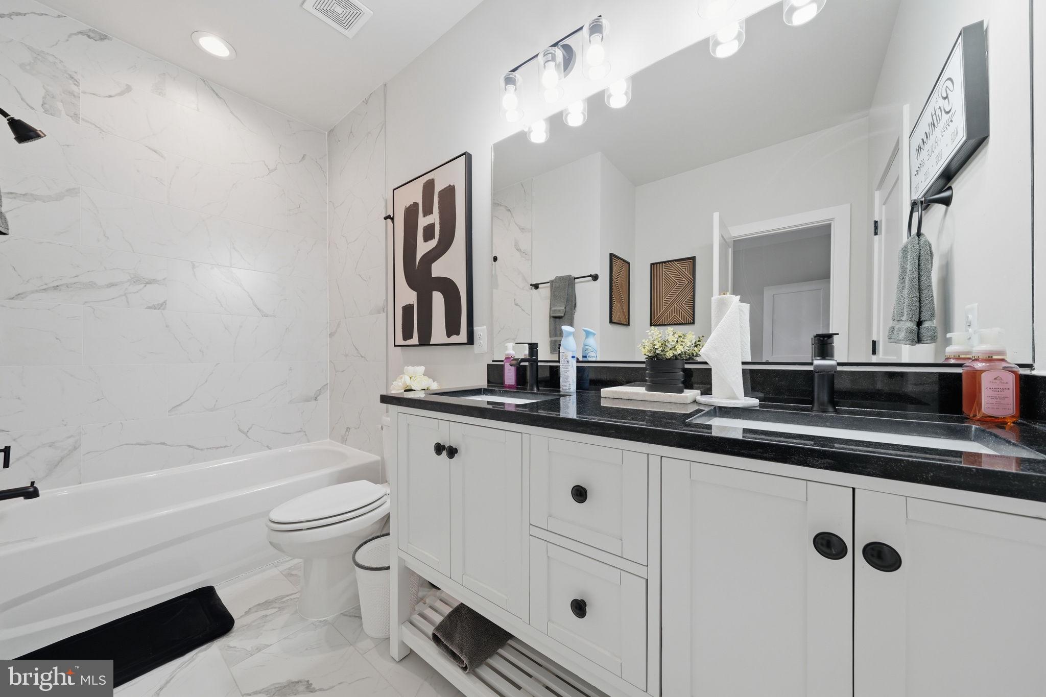 107 Pinewood Lane Colonial Beach, VA 22443 - Photo 18 of 25 a bathroom with a double vanity sink a toilet a mirror and shower