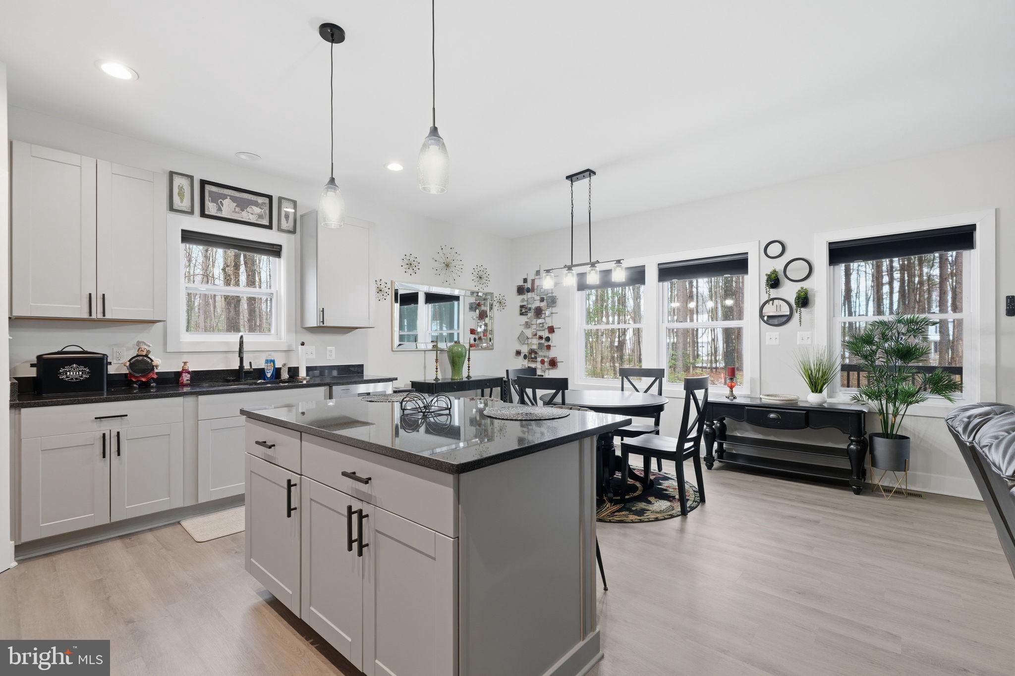 107 Pinewood Lane Colonial Beach, VA 22443 - Photo 4 of 25 a kitchen with stainless steel appliances granite countertop a sink a stove and a wooden floors