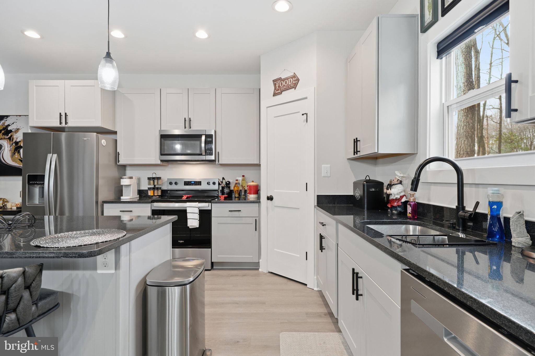 107 Pinewood Lane Colonial Beach, VA 22443 - Photo 7 of 25 a kitchen with granite countertop a sink stainless steel appliances and cabinets