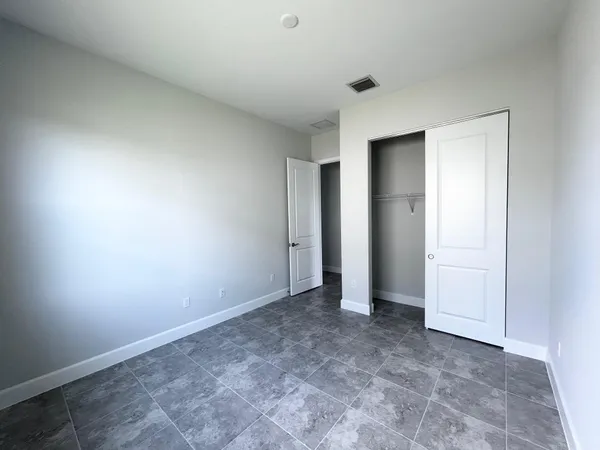 a bathroom with a granite countertop sink a toilet a mirror a bathtub and shower