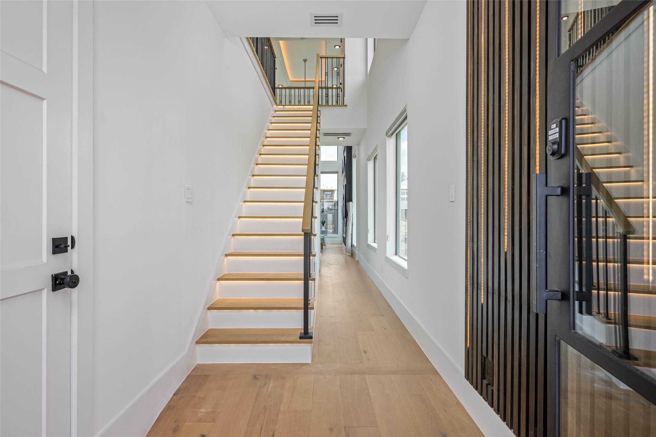 623 Rolling Oaks Stafford, TX 77477 - Photo 5 of 50 Step into a refined foyer with a custom chandelier, optional LED-accented wall paneling, and rich, engineered white oak flooring that exudes timeless elegance