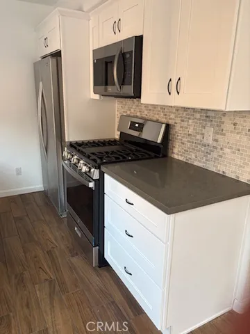 a kitchen with stainless steel appliances granite countertop a stove and a microwave