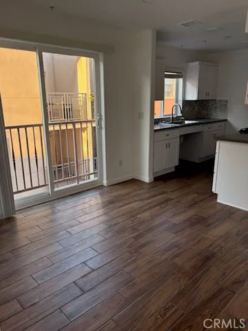 a view of a kitchen with wooden floor and a window