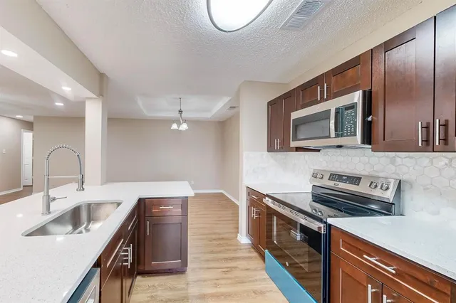 a kitchen with stainless steel appliances granite countertop a refrigerator and a stove top oven