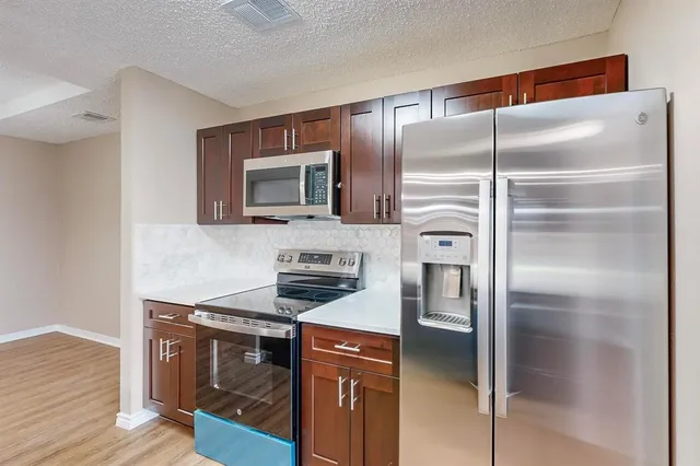 a hallway with cabinets and wooden floor