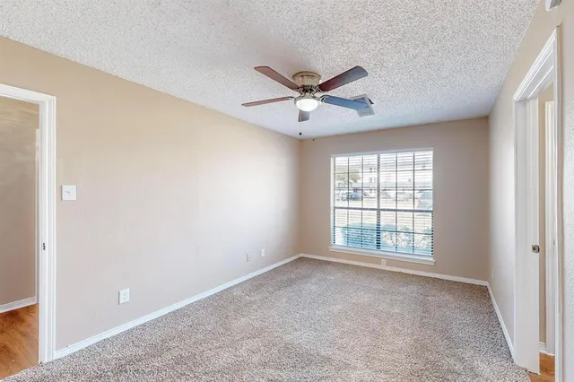 a view of a room with a ceiling fan and a window