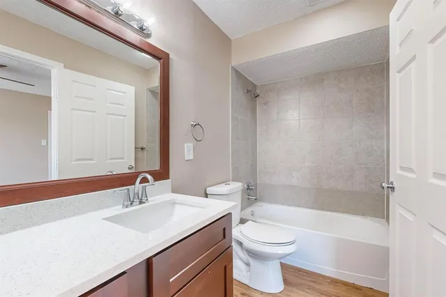 an empty room with ceiling fan and windows