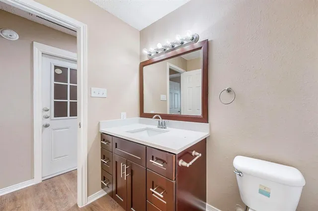 a bathroom with a sink a toilet a mirror and shower