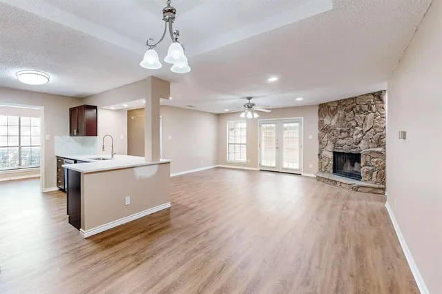 a view of a kitchen with a sink a refrigerator and a fireplace