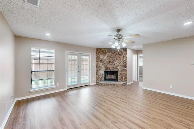 wooden floor fireplace and windows in an empty room