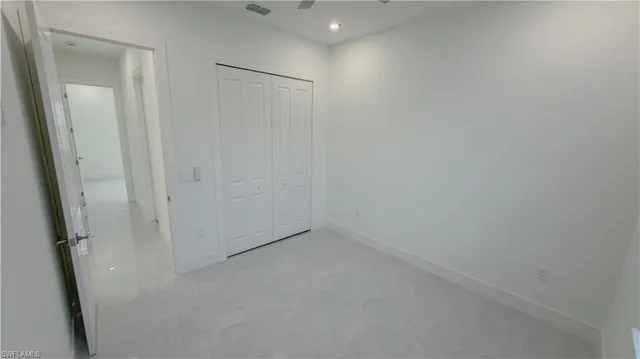 en empty room with a window and a ceiling fan