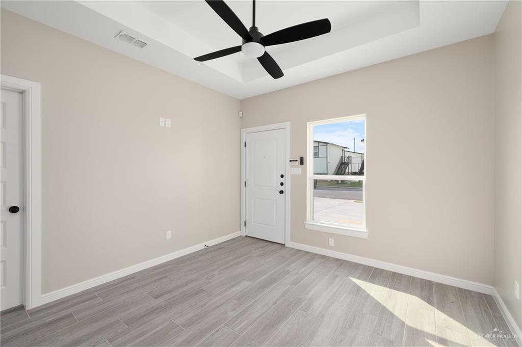 905 Crestview Street Weslaco, TX 78596 - Photo 3 of 10 a view of empty room with wooden floor and ceiling fan