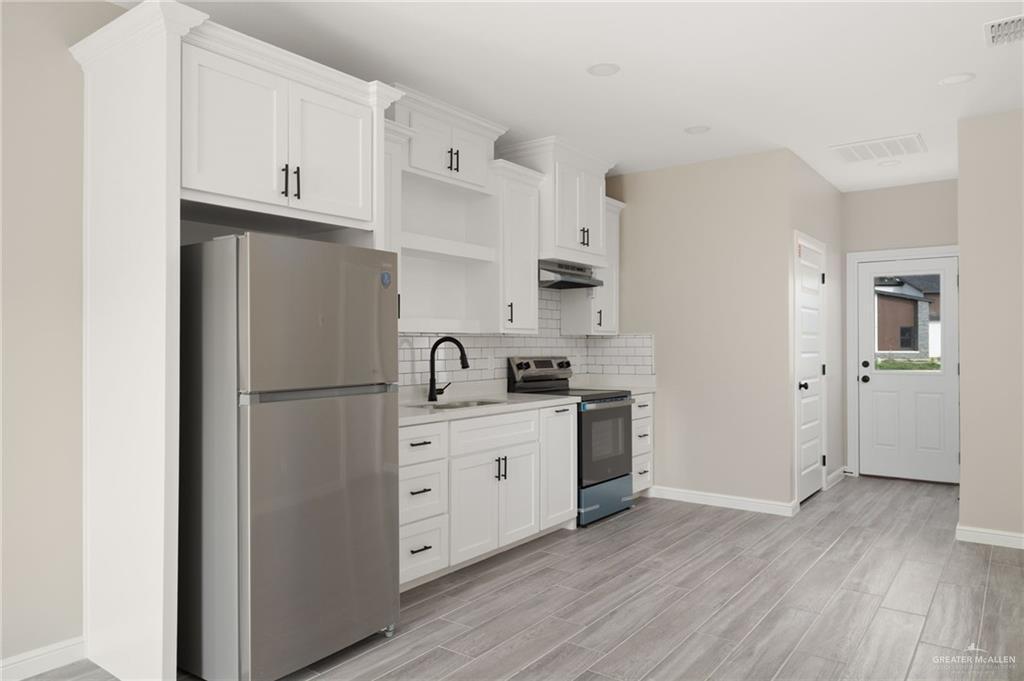 905 Crestview Street Weslaco, TX 78596 - Photo 5 of 10 a kitchen with stainless steel appliances a refrigerator sink and cabinets