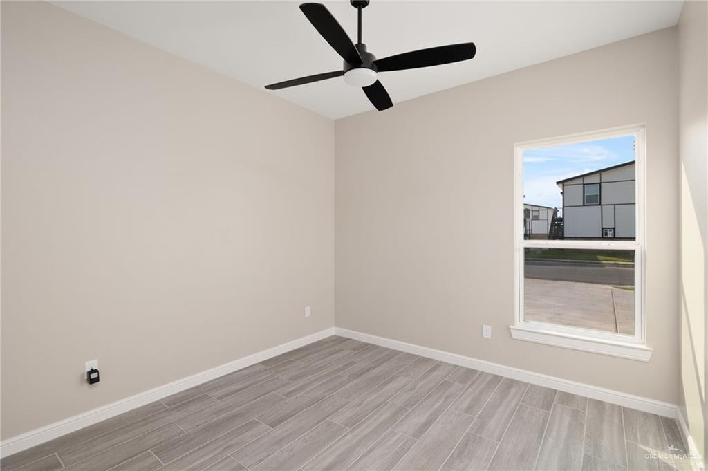 905 Crestview Street Weslaco, TX 78596 - Photo 8 of 10 a view of empty room with wooden floor and fan