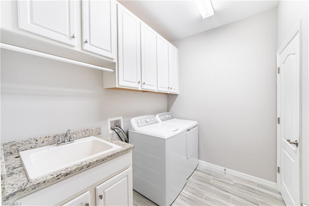 1654 Marton Court Naples, FL 34113 - Photo 11 of 29 Drip bar over utility sink, and plenty of storage in cabinetry over washer/dryer.
