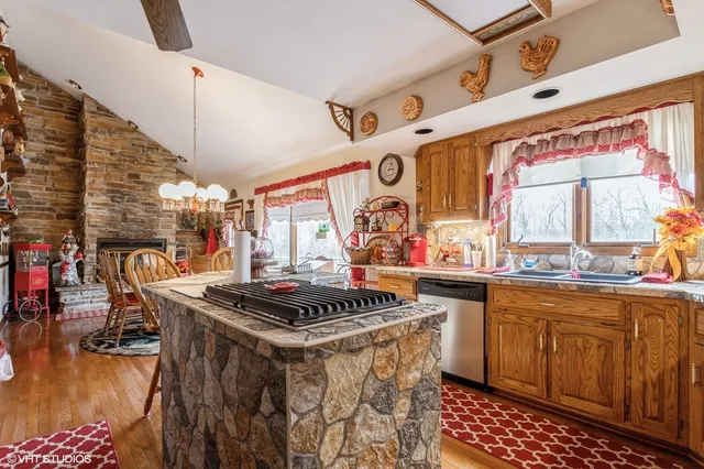 a kitchen with stainless steel appliances a stove a sink dishwasher and cabinets with wooden floor