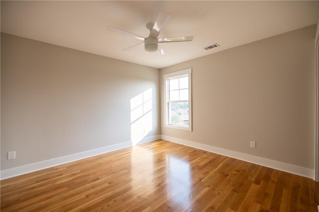 982 Wildberry Court Jefferson, GA 30549 - Photo 40 of 64 an empty room with wooden floor chandelier fan and windows