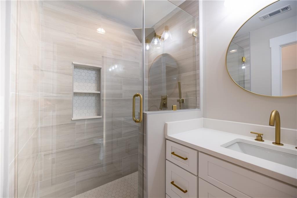 982 Wildberry Court Jefferson, GA 30549 - Photo 45 of 64 a bathroom with a sink a mirror a vanity and shower