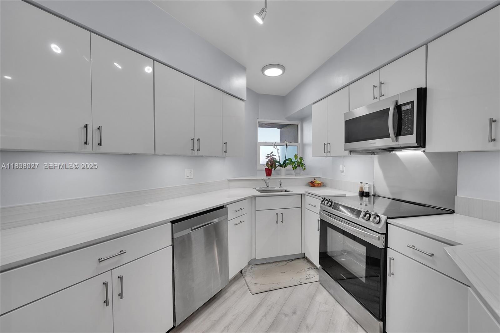 a kitchen with white cabinets stainless steel appliances and sink