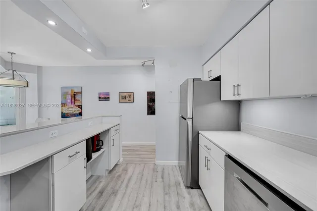 a kitchen with stainless steel appliances a sink dishwasher stove refrigerator and cabinets