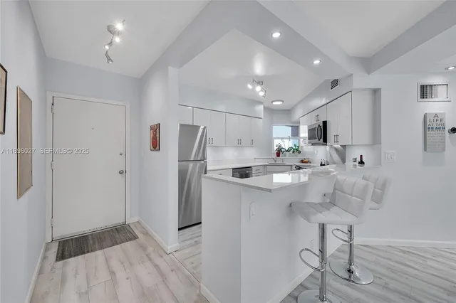 a kitchen with stainless steel appliances a refrigerator sink and cabinets