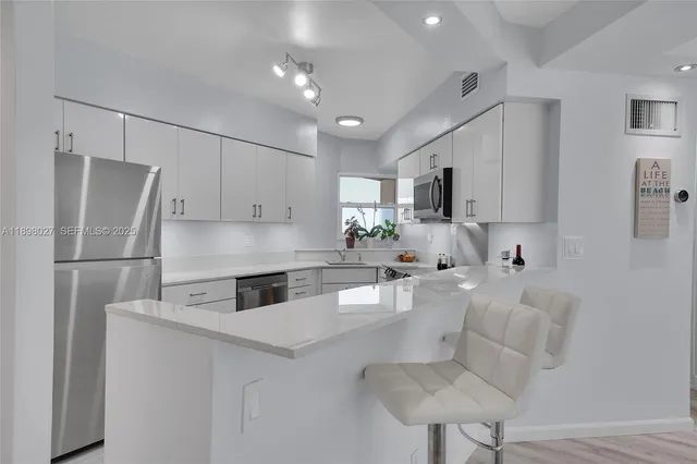 a kitchen with white cabinets and stainless steel appliances