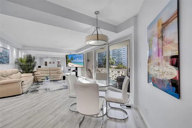 a living room with furniture a dining table and a floor to ceiling window