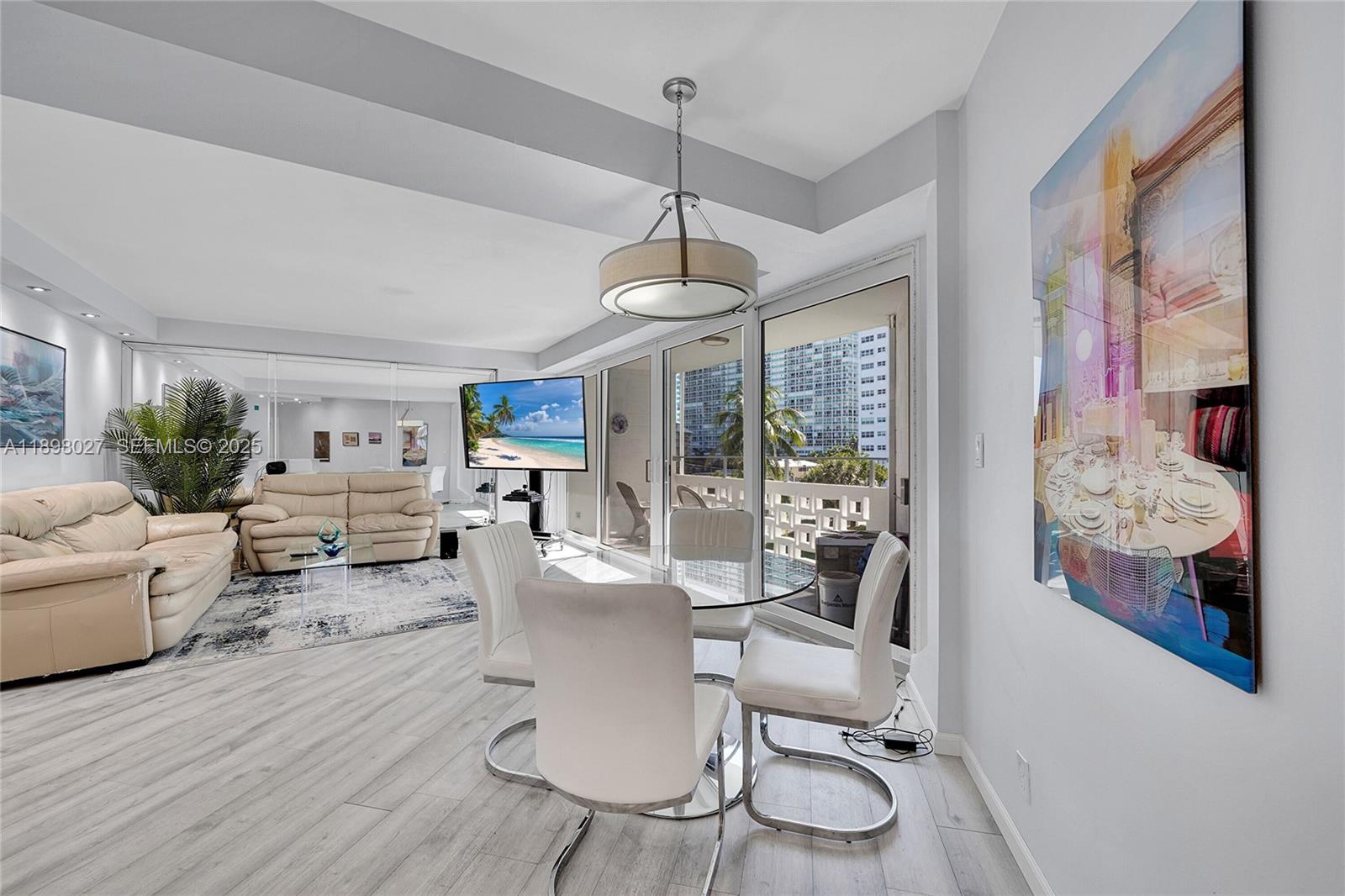 1900 South Ocean Drive, Unit 406 Fort Lauderdale, FL 33316 - Photo 8 of 26 a living room with furniture a dining table and a floor to ceiling window